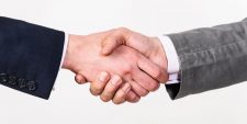 Two people shaking hands as part of a business deal.