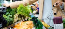 Supermarket customer with a shopping basket, doing their weekly shop.